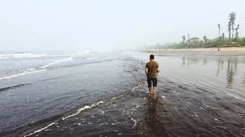 Walking on beach over shallow sea water waves Video stock 157637137