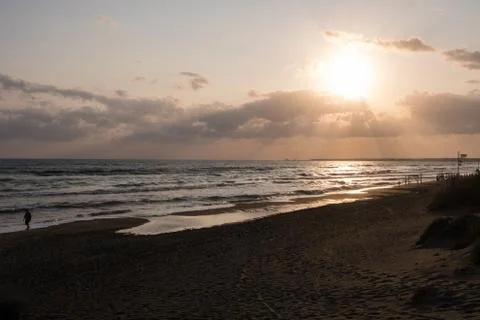 Walking at the beach at sunset. Stock Photos