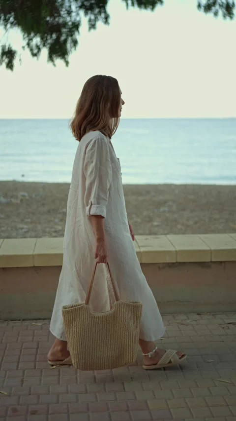 Walking by the beach with a tote bag at sunset Stock Footage 342788235