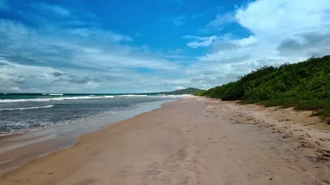 Walking by the beautiful sandy beach with no people. Sea waves slowly roll to Stock Footage 334705149