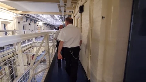 Walking behind prison officers Stock Footage