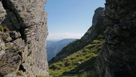 Walking between two rocks during a hike in the Carpathians, in romania Stock Footage 231258932