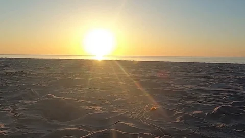 Walking bottom view of sand and small waves break  backlights at dawn or sunset Stock Footage 112064676