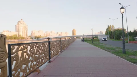 Walking at the boulevard in Central Park with a view of the Atyrau bridge Stockbeeldmateriaal 346572923