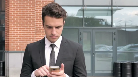 Walking Businessman Using Smartphone Stock Footage 94850490