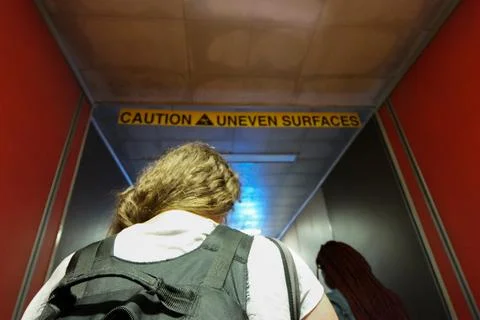 Walking caution uneven surfaces back pack boarding a flight Stock Photos