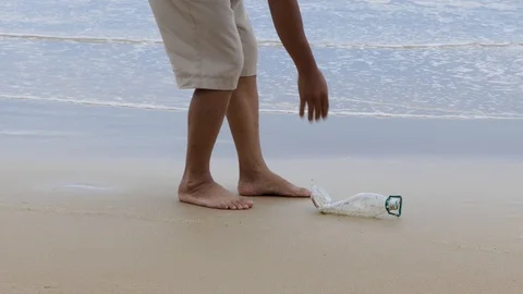 Walking to collect old plastic bottles at the beach to protect the environment. 库存影片 108421218