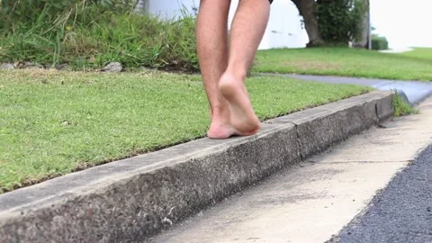Walking on the curbside barefoot Stock Footage 235581586