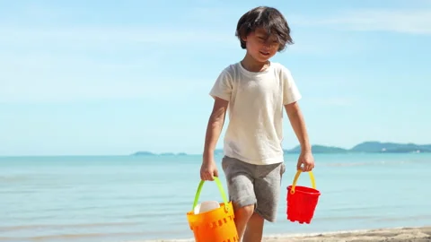 Walking cute boy playing water and sand outside on the beach together Stock-Footage 199263583