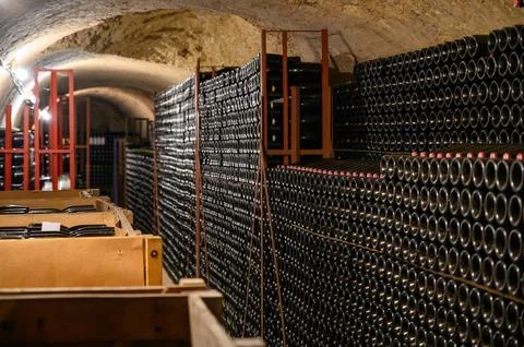 Walking in deep undergrounds caves with bottles on wooden racks, making cha.. Stock Photos