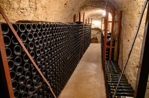 Walking in deep undergrounds caves with bottles on wooden racks, making cha.. Stock Photos