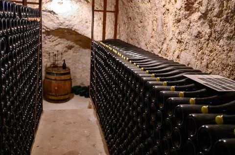 Walking in deep undergrounds caves with bottles on wooden racks, making cha.. Stock Photos