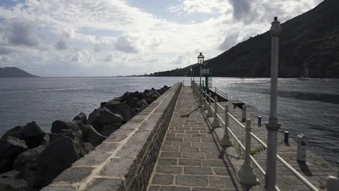 Walking down the harbor mole at Santa Marina Salina, Italy Stock-Footage 120047092