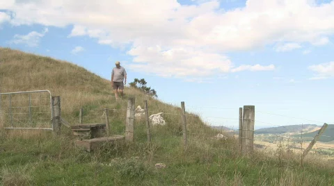 Walking down a hill and crossing a fence Stock Footage 626232
