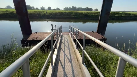 Walking Down a Metal Gangway to a Floating Dock on a Calm River Video stock 340636786