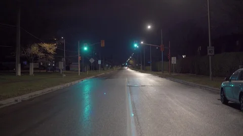Walking down the middle yellow line of a dark suburban street at night Stock Footage 122380730