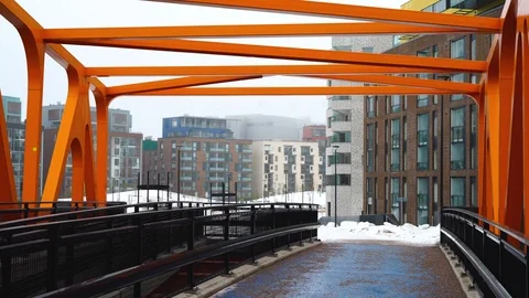 Walking down the modern orange pedestrian bridge Video stock 103867124
