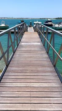 Walking down pier towards docks emphasizing peaceful and tranquil atmosphere of Stock Photos