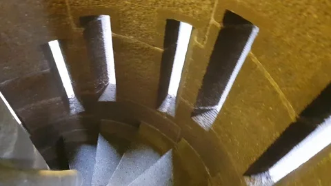 Walking down the round stairs in medieval fortress. Spiral steep stairs in Stock Footage 108670514