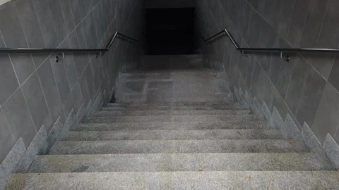 Walking down a staircase on a train platform. Dark tunnel staircase with Stock Footage 127108189