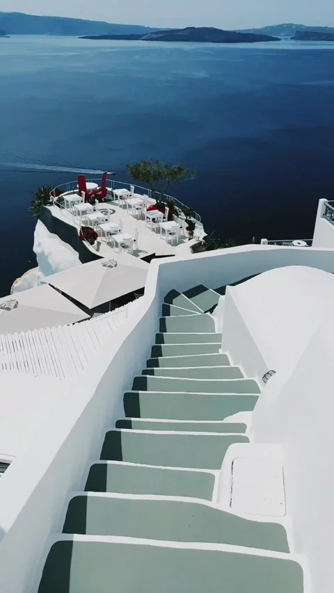 Walking down the stairs with view to luxurious restaurants and the Caldera. Vídeos de archivo 334010377