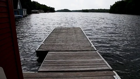 Walking down a wood dock looking onto Lake Joseph, Ontario. Видео 96538174