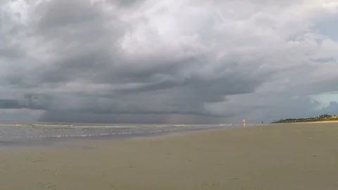 Walking on dramatic cloudy stormy ocean beach Stock Footage 91199500