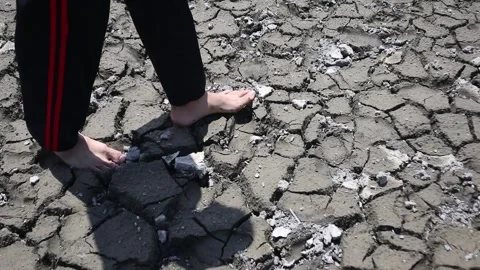 Walking on dry, cracked ground during a prolonged drought. Stock Footage 330829476