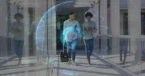 Walking duo pulling suitcase and checking phone in glass hall, white shirt, h Foto stock