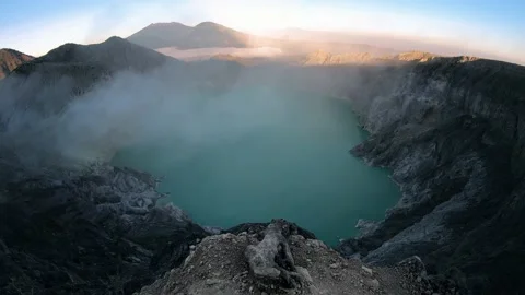 Walking to the edge of the mounain with view over lake on vulcano ijen Stock Footage 146546909