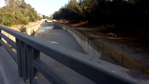 Walking by empty Los Angeles concrete water river channel. Stock Footage 99615129