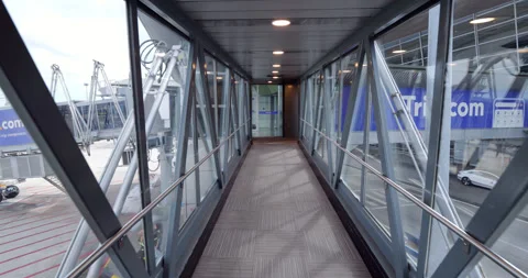 Walking at empty passenger boarding bridge to airport terminal from airplane Stock Footage 314635890