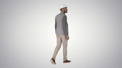 Walking engineer in helmet on gradient background. Stock Photos