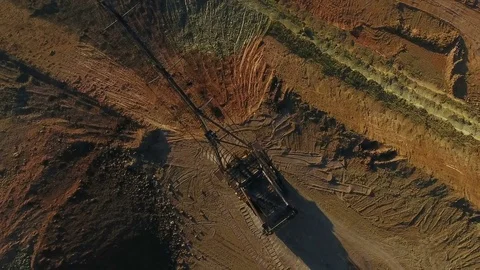 Walking excavator draws ore. Sunset. Bird's eye view Stock Footage 73431950