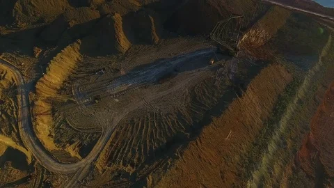 Walking excavator draws ore. Sunset. Bird's eye view Stock Footage 73590988