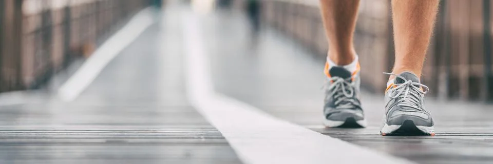 Walking exercise outside on city street banner. Running shoes closeup of man on Stock Photos