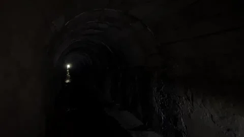 Walking with flashlights through a dark tunnel  Stock Footage 273192425