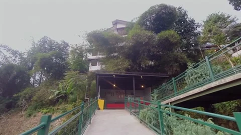 Walking forward on a pedestrian bridge path towards a hillside Stock Footage 345654026