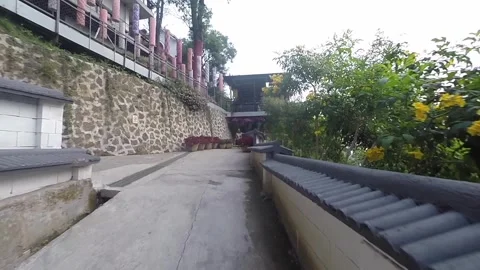 Walking forward on an uphill path slope with traditional wall and nature view Stock Footage 345645099