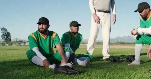 Walking into frame initiating strategic huddle, diverse baseball team standing Stock Footage 338060199