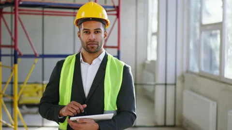 Walking in front of the camera good looking man MAN engineer he analysing the Stock Footage 214254819
