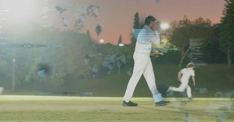 Walking front cricketer in whites shielding face on dusk grass field, with Stock Photos