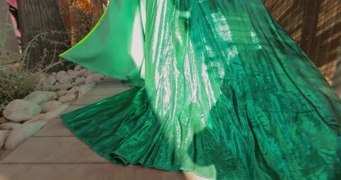 Is Walking go go dancer in a beautiful long green dress, the dress sways in the Stock Footage 182115908