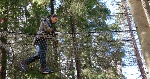 Walking on the grid rope stretched between trees, Climbing park "Nut" Stock Footage 88996499