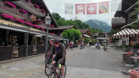 Walking Gstaad Square with Cyclists Passing By Stock Footage 340369482