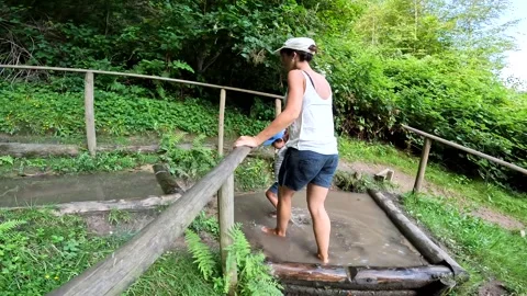 Walking happily barefoot through a forest in a sensory park to enjoy nature Stock Footage 293928328