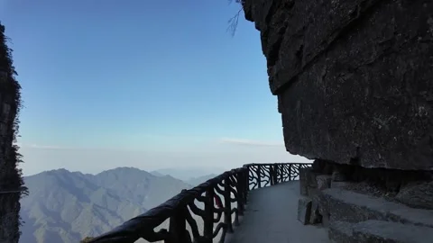 Walking on a hiking path along the edge of a steep cliff with mountain view. Vídeos de archivo 295046138