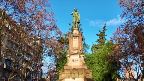 Walking to the historic bronze statue of Monument to Clavé as composer and Stock Footage 328389441