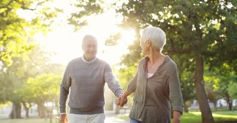 Walking, holding hands and a senior couple outdoor at a park with a love, care Fotos de archivo