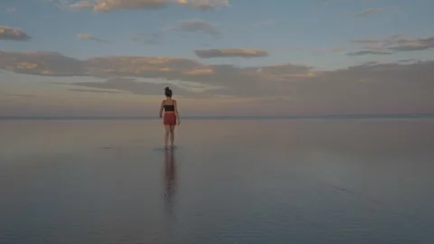 Walking Into Infinity: Girl on Endless Reflective Water Stock Footage 305532909